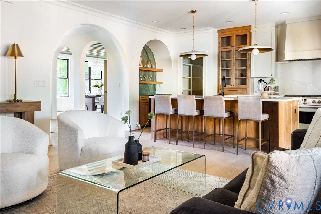 4507 Leonard Parkway, Richmond, VA 23221 Expansive open-concept living area featuring a kitchen island with seating, arched doorways, light wood-finish flooring, white cabinetry, and a built-in range hood