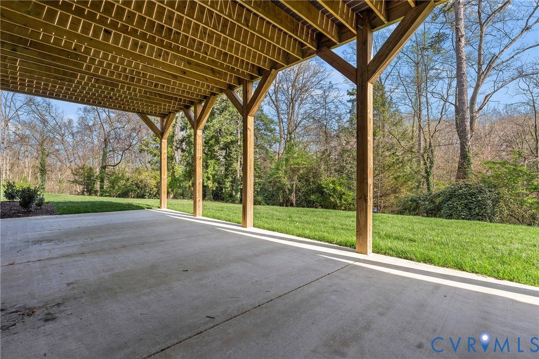 7301 Riverside Drive, Richmond, VA 23225 Covered concrete patio with wooden support columns, overlooking a grassy area and mature trees