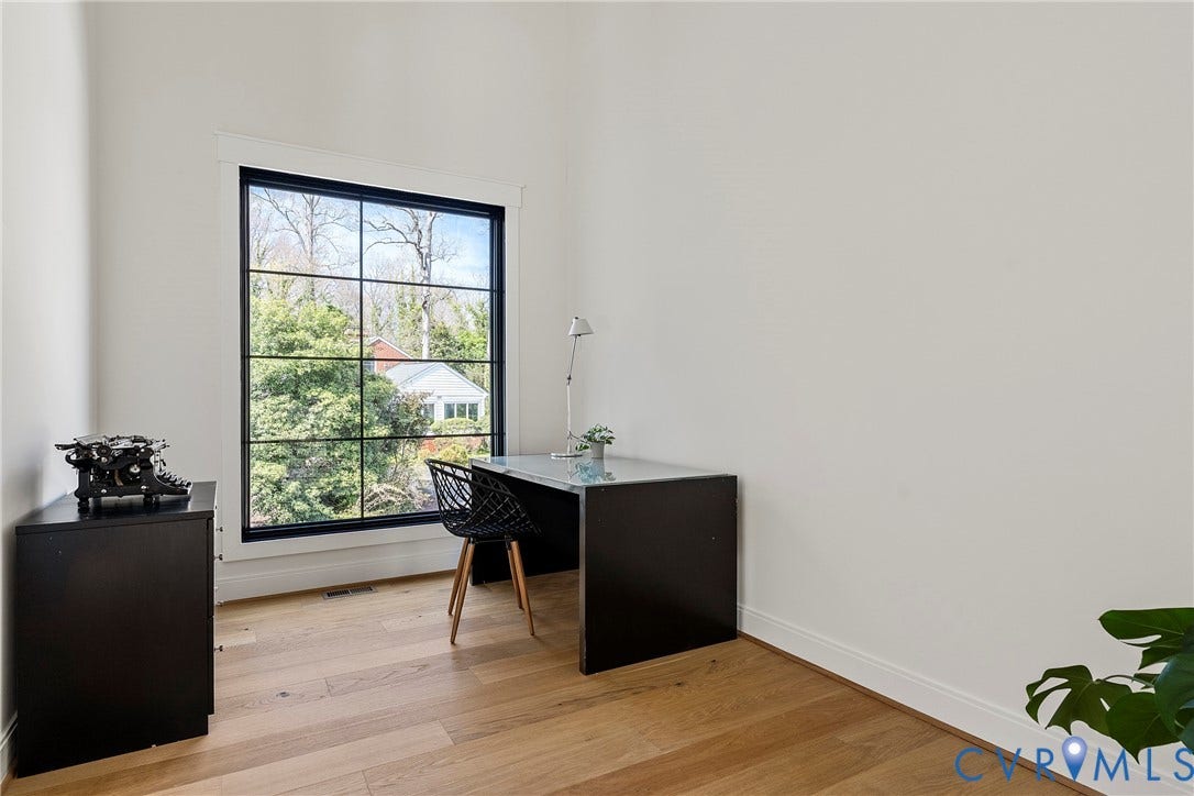 7301 Riverside Drive, Richmond, VA 23225 Room featuring a large grid-pattern window, light wood-finish flooring, white walls, and white trim