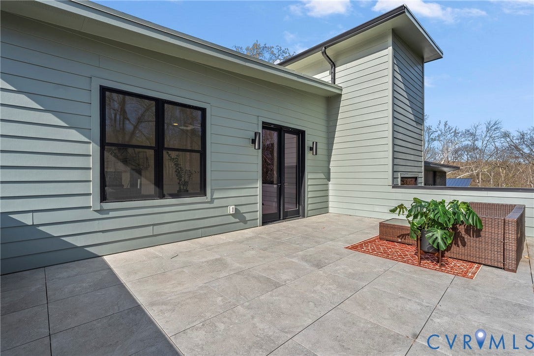 7301 Riverside Drive, Richmond, VA 23225 Expansive outdoor patio featuring large format tile flooring, light green horizontal siding, and black framed glass French doors