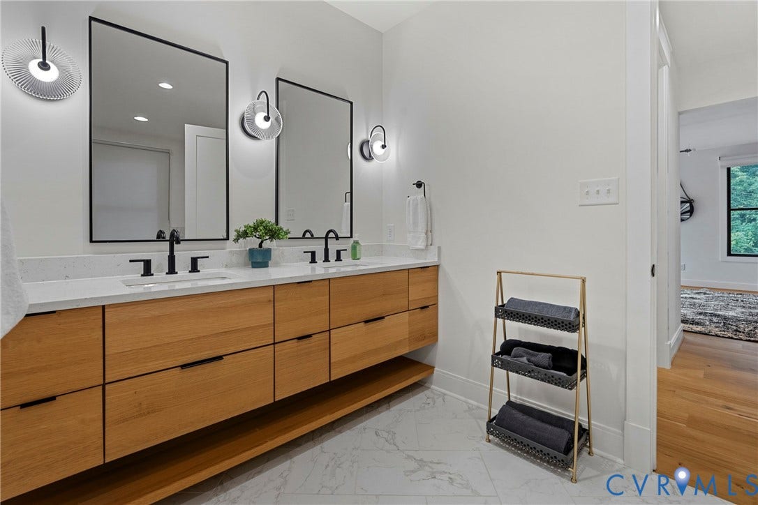 7301 Riverside Drive, Richmond, VA 23225 Double vanity with warm wood-finish cabinetry and a white countertop