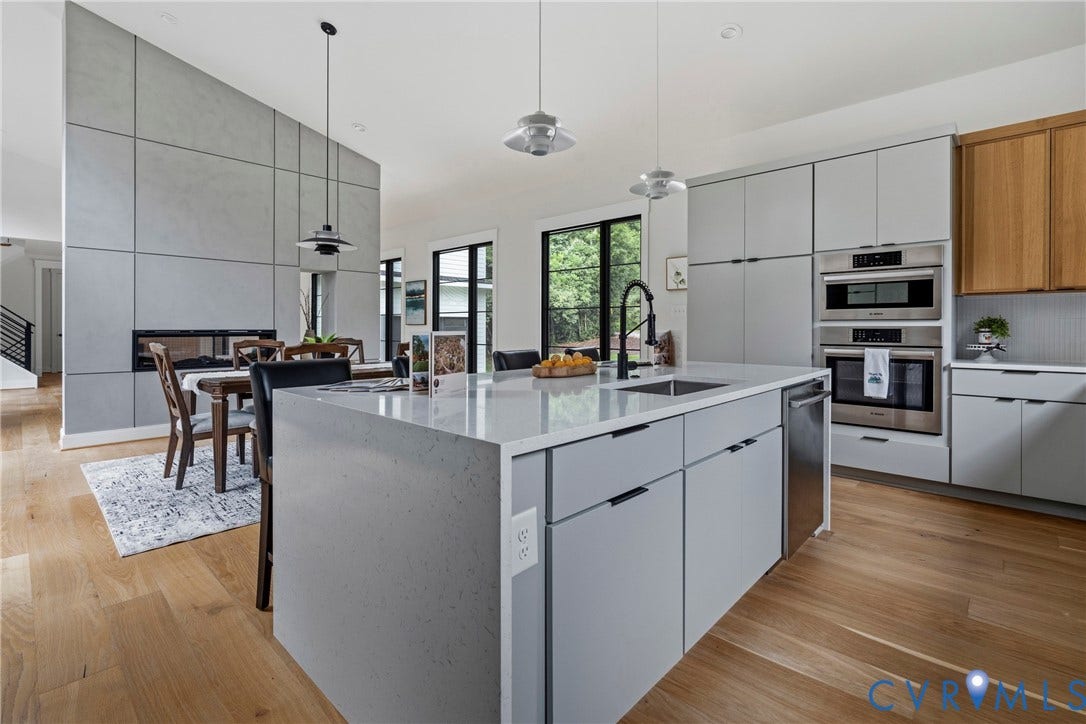 7301 Riverside Drive, Richmond, VA 23225 Spacious kitchen island featuring a waterfall countertop, integrated sink, and modern cabinetry