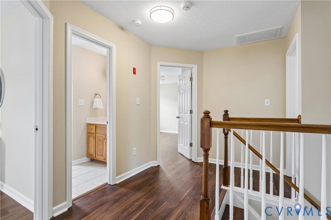 21 St Johns Drive, Hampton, VA 23666 Second-story hallway featuring wood-finish flooring, light tan wall paint, and white trim