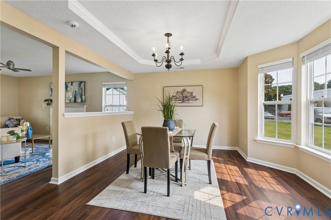 21 St Johns Drive, Hampton, VA 23666 Dining area featuring wood-finish flooring, a tray ceiling, and a chandelier