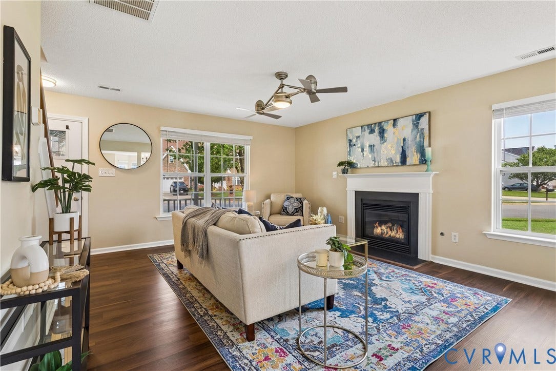 21 St Johns Drive, Hampton, VA 23666 Living area with wood-finish flooring, a white mantel fireplace, and ample natural light from multiple windows