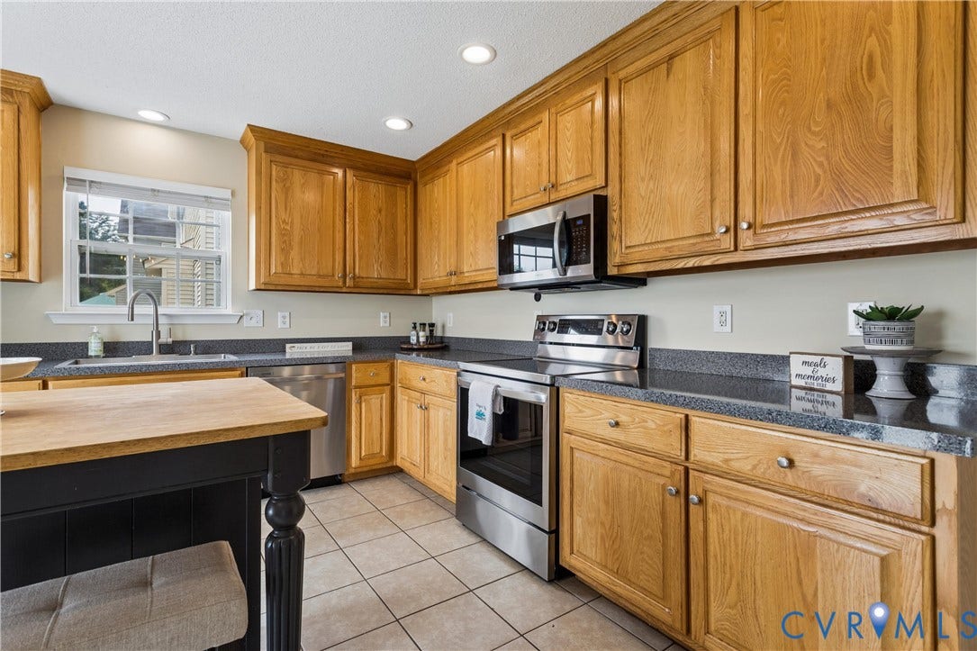 21 St Johns Drive, Hampton, VA 23666 Kitchen featuring wood cabinetry, stainless steel appliances, dark countertops, and tile flooring