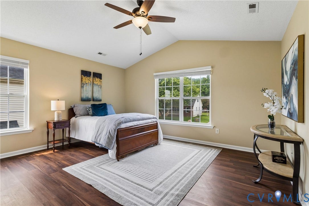 21 St Johns Drive, Hampton, VA 23666 Vaulted ceiling bedroom featuring dark wood-finish flooring, a ceiling fan with light fixture, and multiple windows with blinds