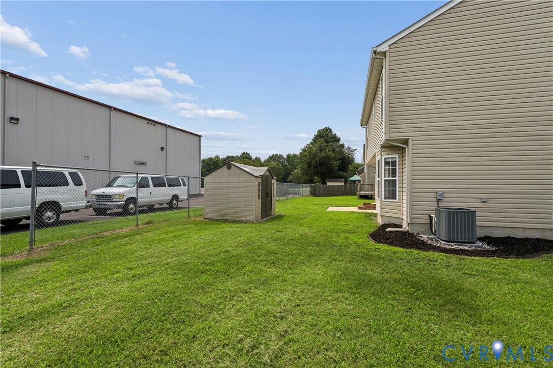 21 St Johns Drive, Hampton, VA 23666 Grassy side yard featuring a functional storage shed and chain-link fencing