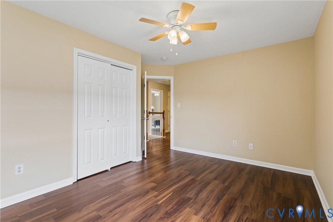 21 St Johns Drive, Hampton, VA 23666 Spacious room featuring wood-finish flooring, light tan walls, and a white ceiling fan with light fixture