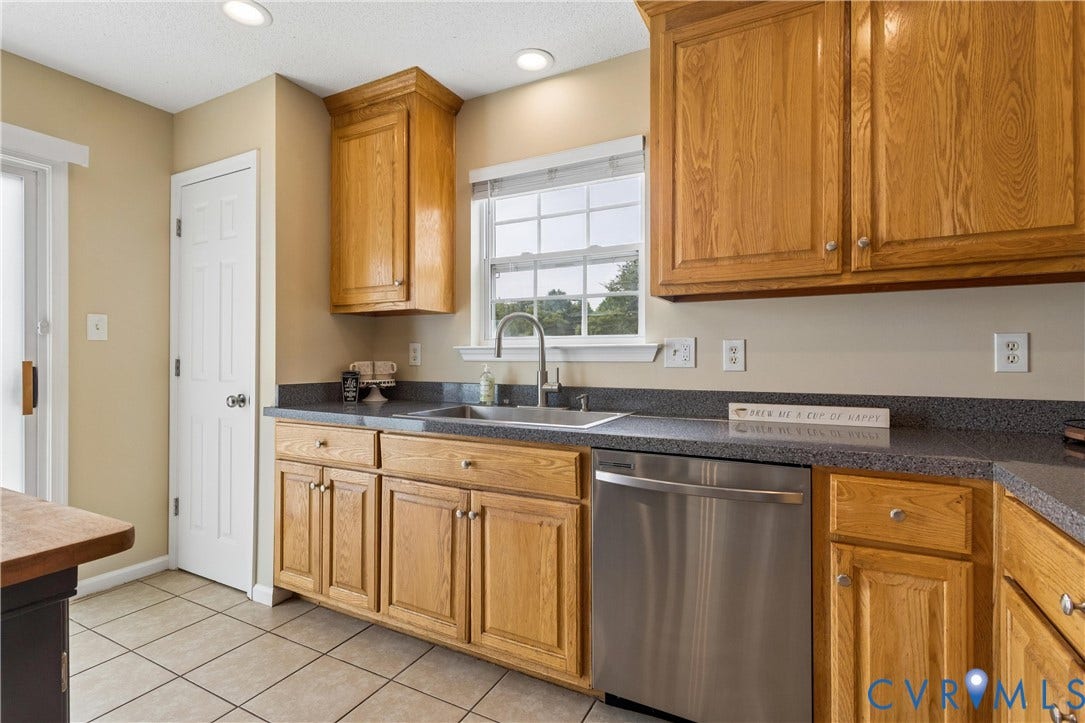 21 St Johns Drive, Hampton, VA 23666 Kitchen featuring wood cabinetry, dark speckled countertops, a stainless steel dishwasher, and a stainless steel sink with a gooseneck faucet