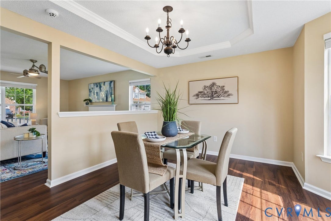 21 St Johns Drive, Hampton, VA 23666 Dining area featuring wood-finish flooring, a tray ceiling with a chandelier, and a pass-through window to an additional living space