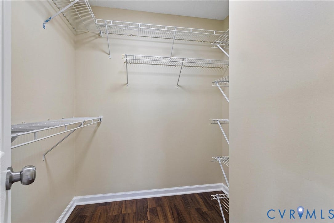21 St Johns Drive, Hampton, VA 23666 Spacious walk-in closet featuring multiple white wire shelving units and rich wood-finish flooring