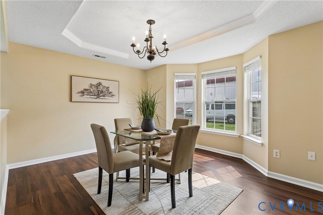 21 St Johns Drive, Hampton, VA 23666 Tray ceiling with crown molding, wood-finish flooring, a bay window with three vertical windows, and a chandelier lighting fixture