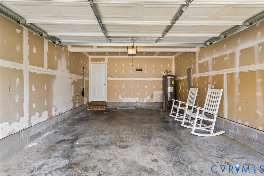 21 St Johns Drive, Hampton, VA 23666 Two-car garage featuring a concrete floor, exposed drywall, and a white overhead door