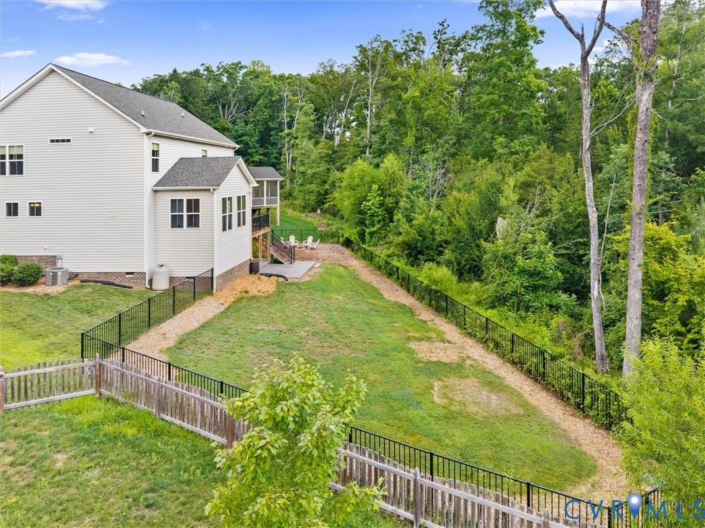 16701 Laurel Park Drive, Moseley, VA 23120 Expansive backyard featuring a manicured lawn, a gravel pathway, and mature trees