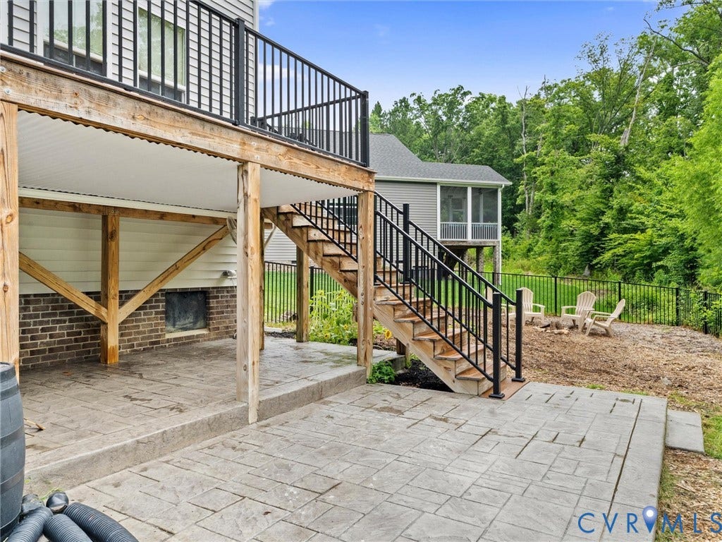 16701 Laurel Park Drive, Moseley, VA 23120 Lower-level stamped concrete patio with direct deck access via exterior staircase, featuring a screened porch, and a fenced perimeter