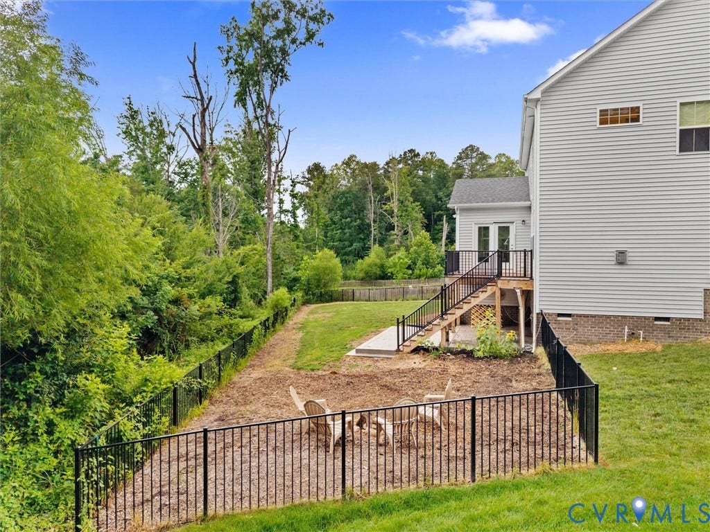 16701 Laurel Park Drive, Moseley, VA 23120 Expansive outdoor space featuring a multi-level fenced yard, a wooden deck with black railings, and a walk-out basement patio