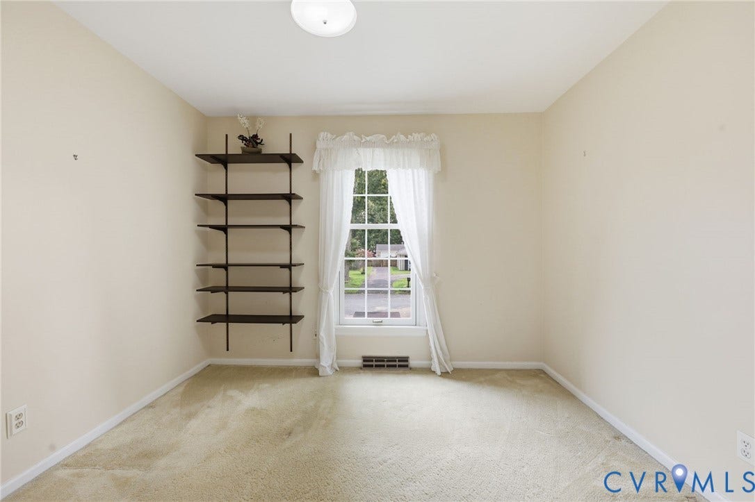 121 Huntington Road, Colonial Heights, VA 23834 Room with soft beige wall paint, light-colored carpet flooring, a multi-pane window, and a built-in shelving unit