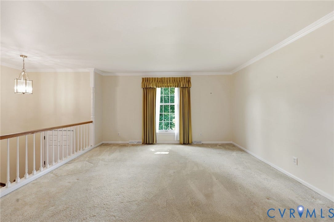 121 Huntington Road, Colonial Heights, VA 23834 Spacious room featuring neutral carpeting, a large window with ample natural light, crown molding, and a chandelier-style light fixture