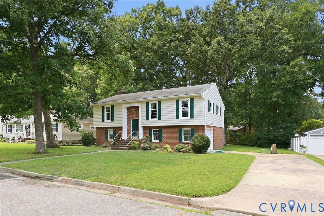 121 Huntington Road, Colonial Heights, VA 23834 Split-level residence featuring light-colored siding, dark green shutters, and a brick base