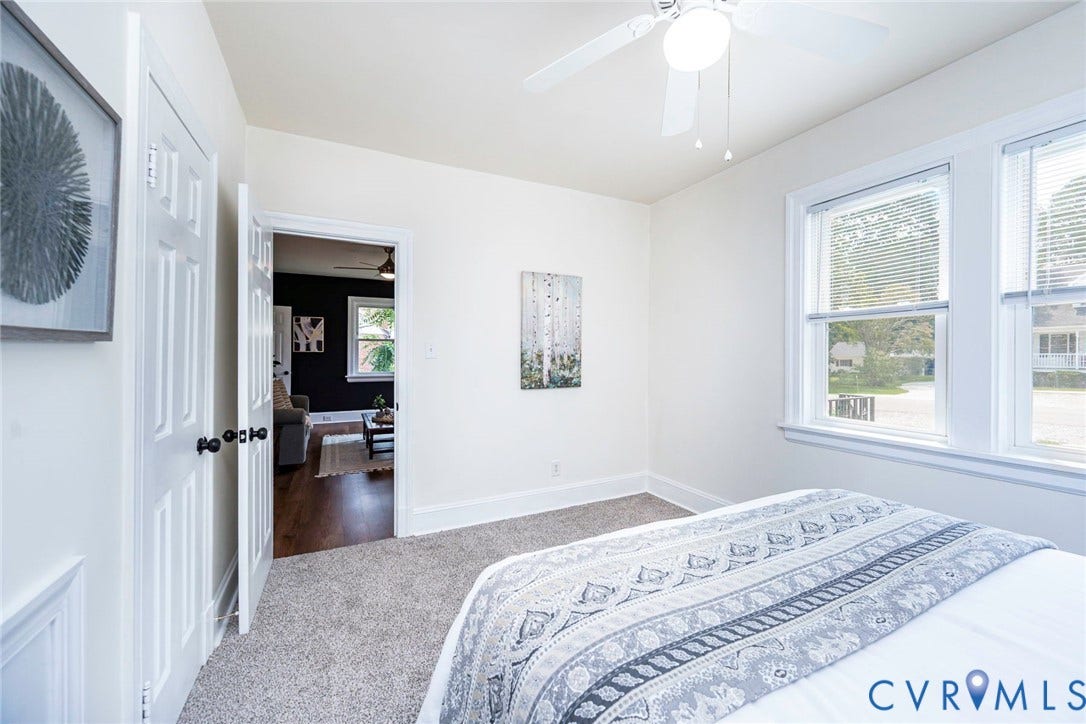 1402 Rhode Island Avenue, Glen Allen, VA 23060 Bright interior featuring two white-framed windows, a ceiling fan with light fixture, light gray carpet flooring, and white paneled doors
