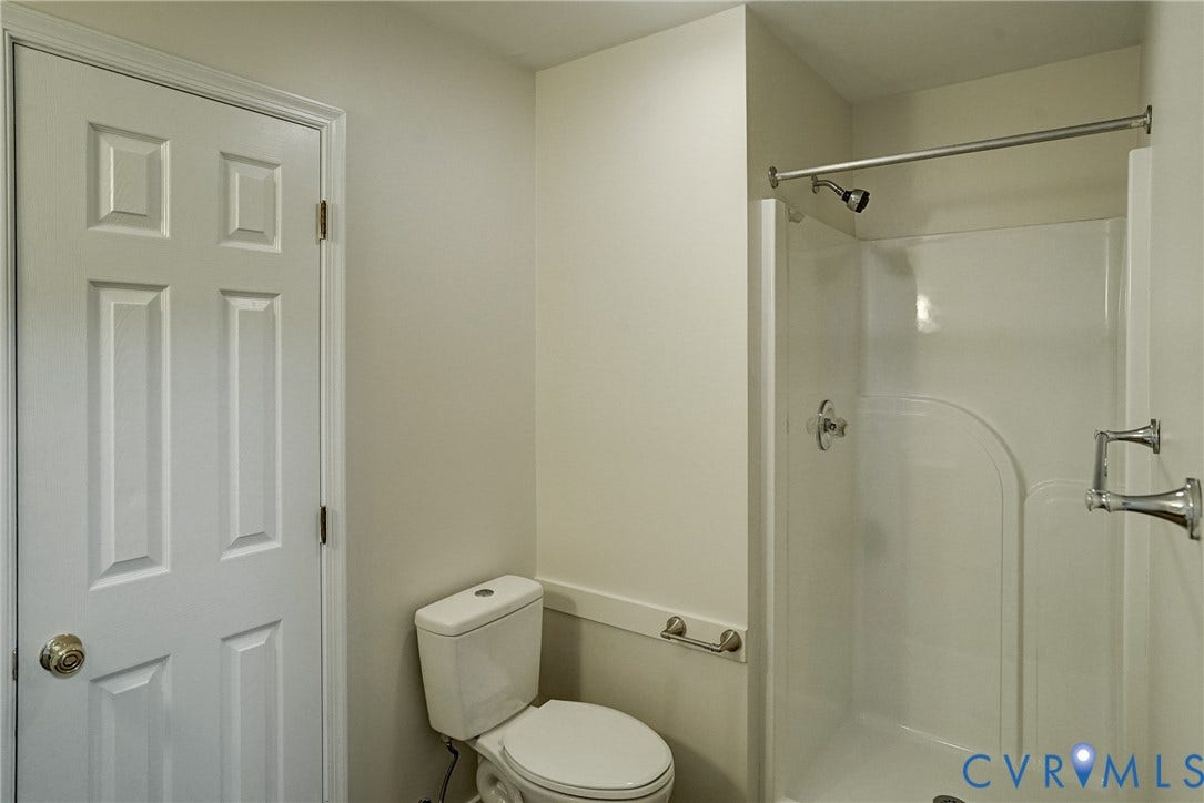 2221 High Bush Circle, Glen Allen, VA 23060 1st Floor Full Bathroom featuring a white paneled door, a white toilet, and a white shower stall with chrome fixtures