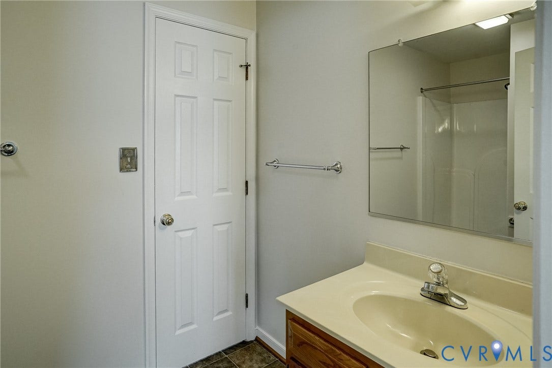 2221 High Bush Circle, Glen Allen, VA 23060 1st Floor Full Bathroom vanity featuring a laminate countertop with an integrated sink, chrome faucet, and wood-finish cabinetry