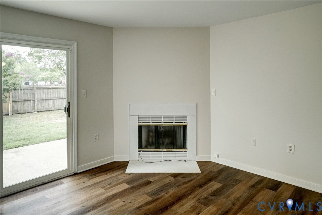 2221 High Bush Circle, Glen Allen, VA 23060 Interior space featuring wood-finish flooring, a white trim fireplace with a hearth, and a sliding glass door