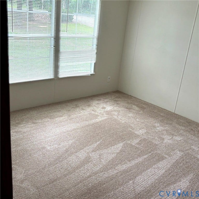 Wall-to-wall neutral-toned carpeting enhances this interior space