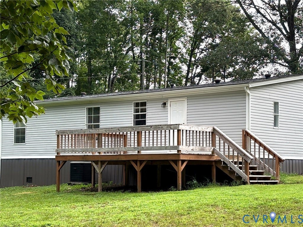 Rear exterior featuring light gray horizontal siding and a full-length wooden deck