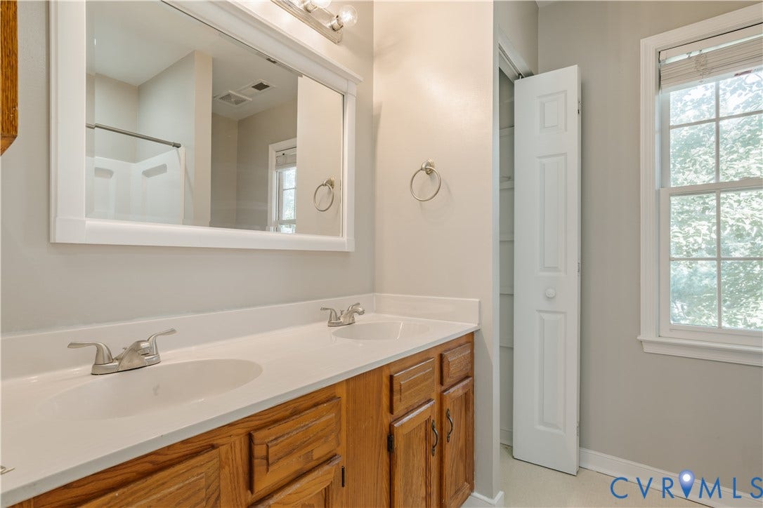 Dual vanity and linen closet in en-suite primary bath