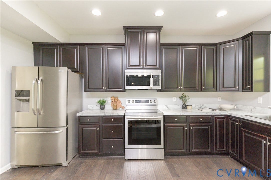 12814 Bailey Hill Court, Bayhill Pointe, Midlothian, VA 23112 Dark wood-finish cabinetry, stainless steel appliances, light-toned countertops, wood-finish flooring, and recessed lighting