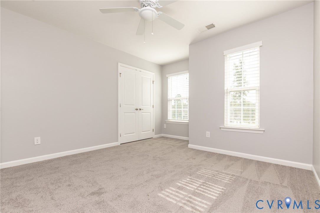 12814 Bailey Hill Court, Bayhill Pointe, Midlothian, VA 23112 Light gray painted walls, two windows with white blinds, white bi-fold closet doors, white ceiling fan, and gray carpet