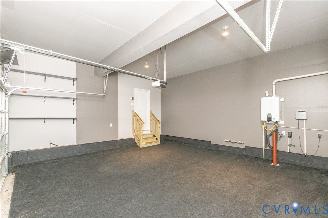 12814 Bailey Hill Court, Bayhill Pointe, Midlothian, VA 23112 Garage space featuring a concrete floor, painted gray walls, a staircase with wood railing, and a wall-mounted water heater