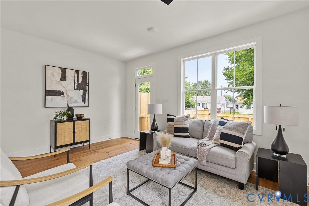 Wood-finish flooring throughout, white walls, and a large window with white trim