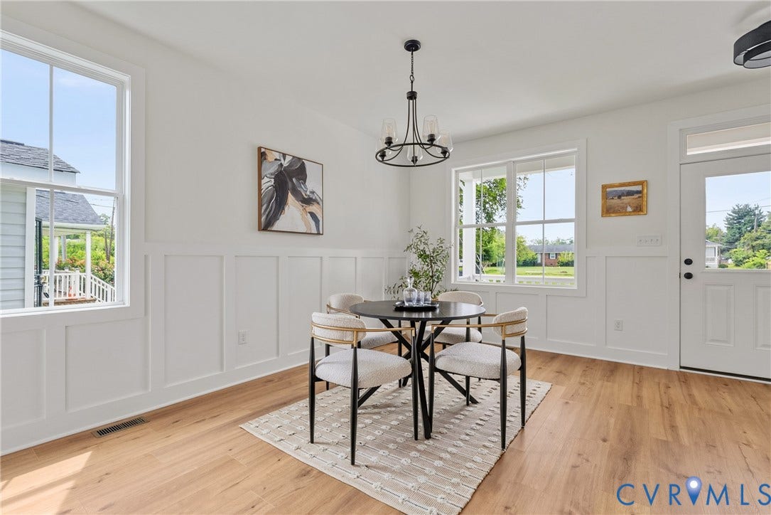 Board and batten wainscoting, wood-finish flooring, multiple windows, transom window, and a glass-paneled entry door