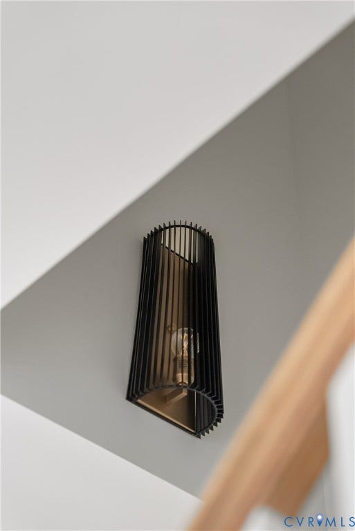 Sleek wall-mounted sconce with a linear black metal shade and an exposed bulb