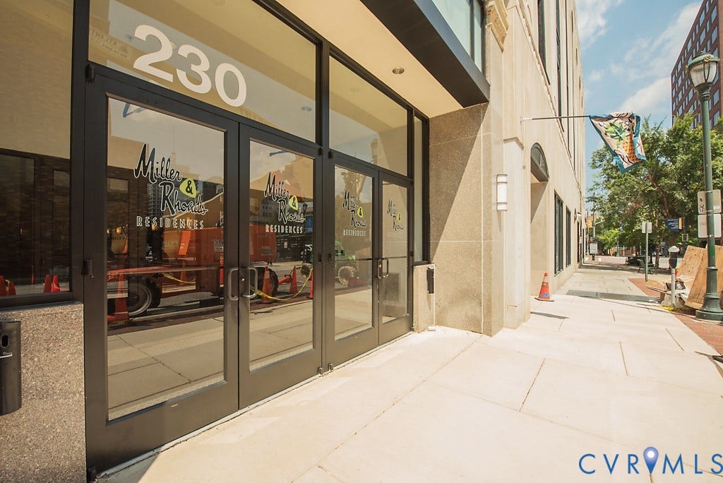 230 N 6th Street, #U325, Richmond, VA 23219 Glass double doors with dark frames, light-colored exterior stonework, and contemporary wall sconces