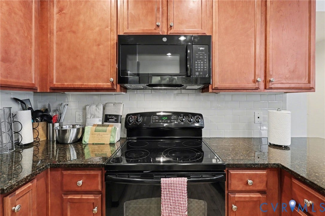 230 N 6th Street, #U325, Richmond, VA 23219 Kitchen featuring rich wood cabinetry, dark speckled countertops, a black electric range, and a built-in black microwave