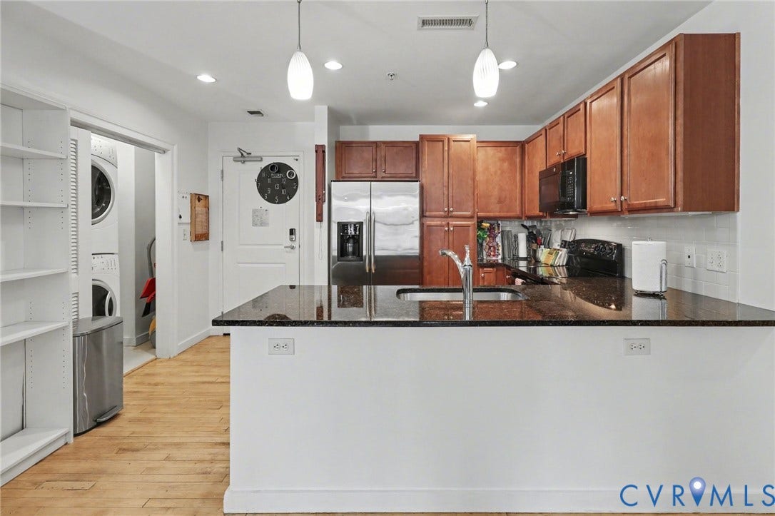 230 N 6th Street, #U325, Richmond, VA 23219 Kitchen featuring wood-finish flooring, dark stone countertops, wood cabinetry, and stainless steel appliances