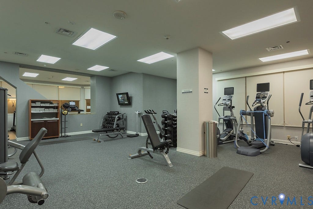 230 N 6th Street, #U325, Richmond, VA 23219 Dedicated fitness center featuring textured gray flooring, recessed lighting, wall-mounted television, and a variety of exercise equipment