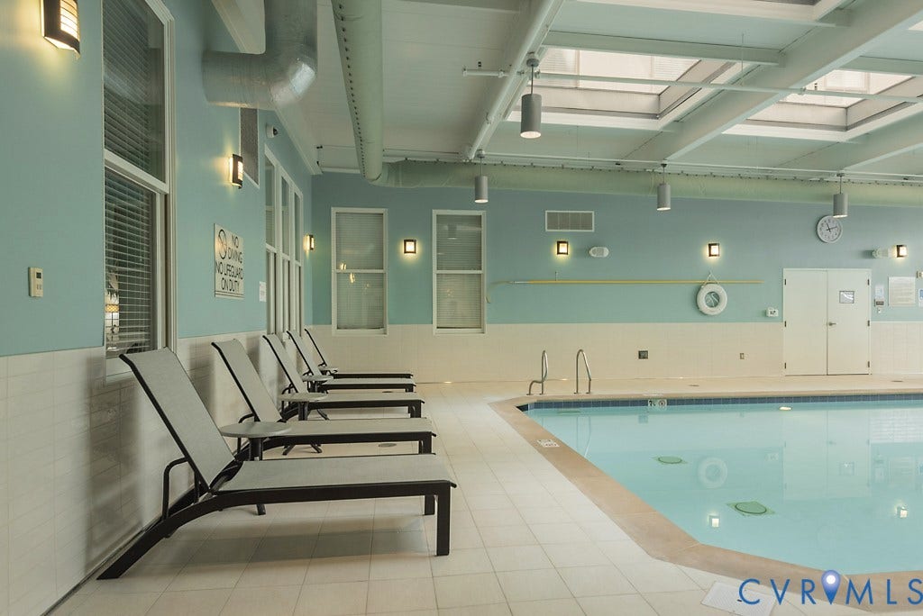 230 N 6th Street, #U325, Richmond, VA 23219 Indoor swimming pool featuring light blue walls, multiple skylights, and perimeter lounge seating