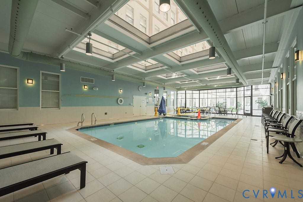 230 N 6th Street, #U325, Richmond, VA 23219 Indoor swimming pool with large skylights, expansive windows, tiled deck, and overhead lighting