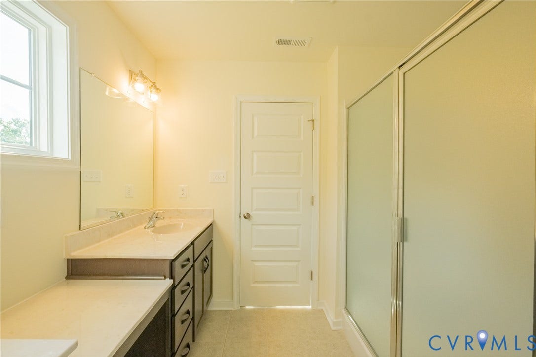 18429 Palisades Court, Chesterfield, VA 23120 Bathroom featuring a vanity with an integrated sink, light-toned countertop, and dark wood-finish cabinetry