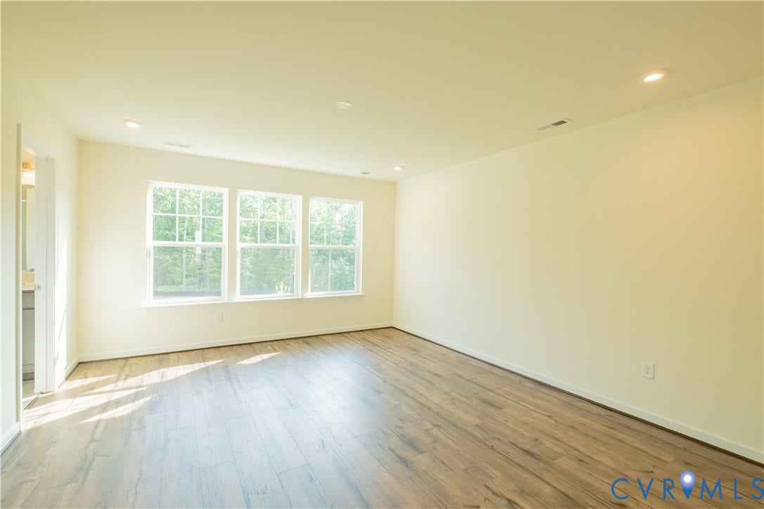 18429 Palisades Court, Chesterfield, VA 23120 Spacious room featuring three large windows, wood-finish flooring, recessed lighting, and light-toned walls