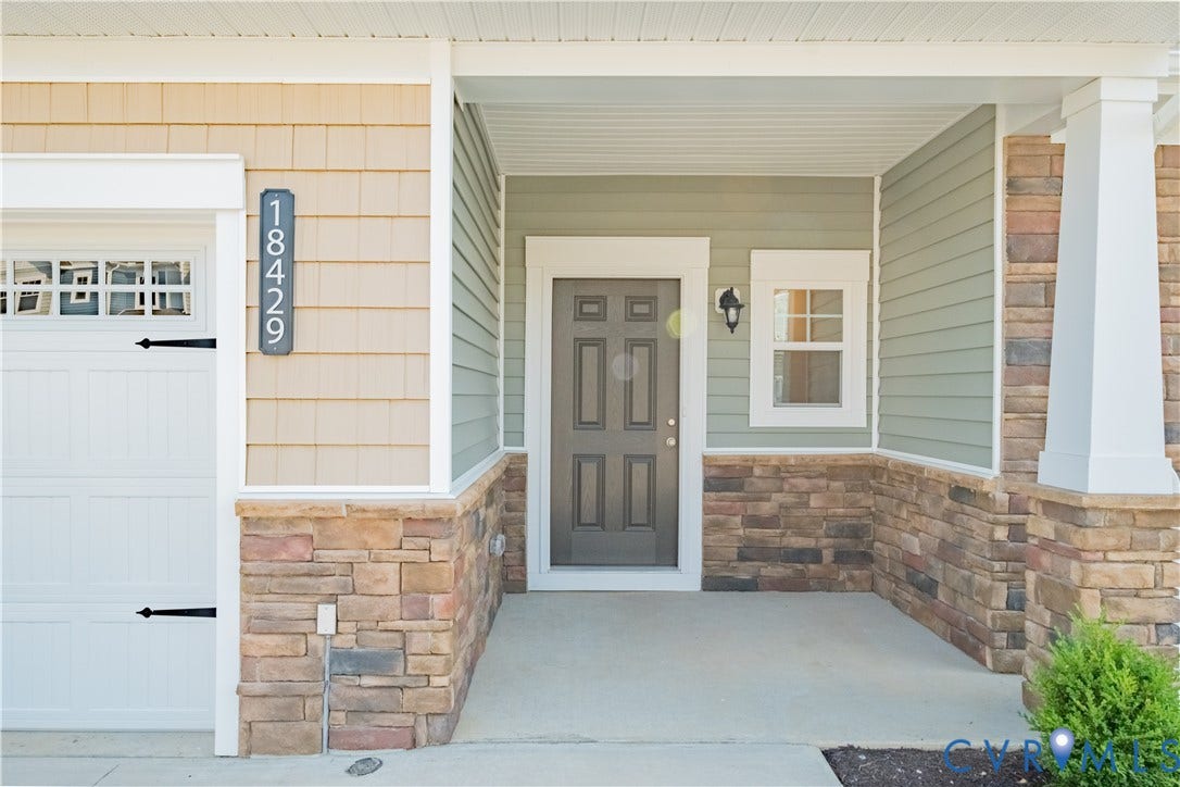18429 Palisades Court, Chesterfield, VA 23120 Covered front porch featuring a multi-panel entry door, a sidelight window, stone veneer accents, horizontal siding, and shake siding