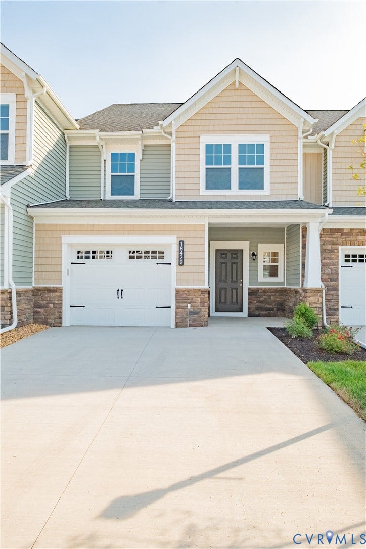 18429 Palisades Court, Chesterfield, VA 23120 Contemporary townhouse exterior featuring a two-car garage, concrete driveway, and stone facade accents