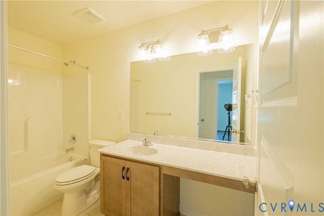 18429 Palisades Court, Chesterfield, VA 23120 Bathroom featuring a single vanity with wood cabinetry, an integrated sink, a solid surface countertop, and an expansive mirror