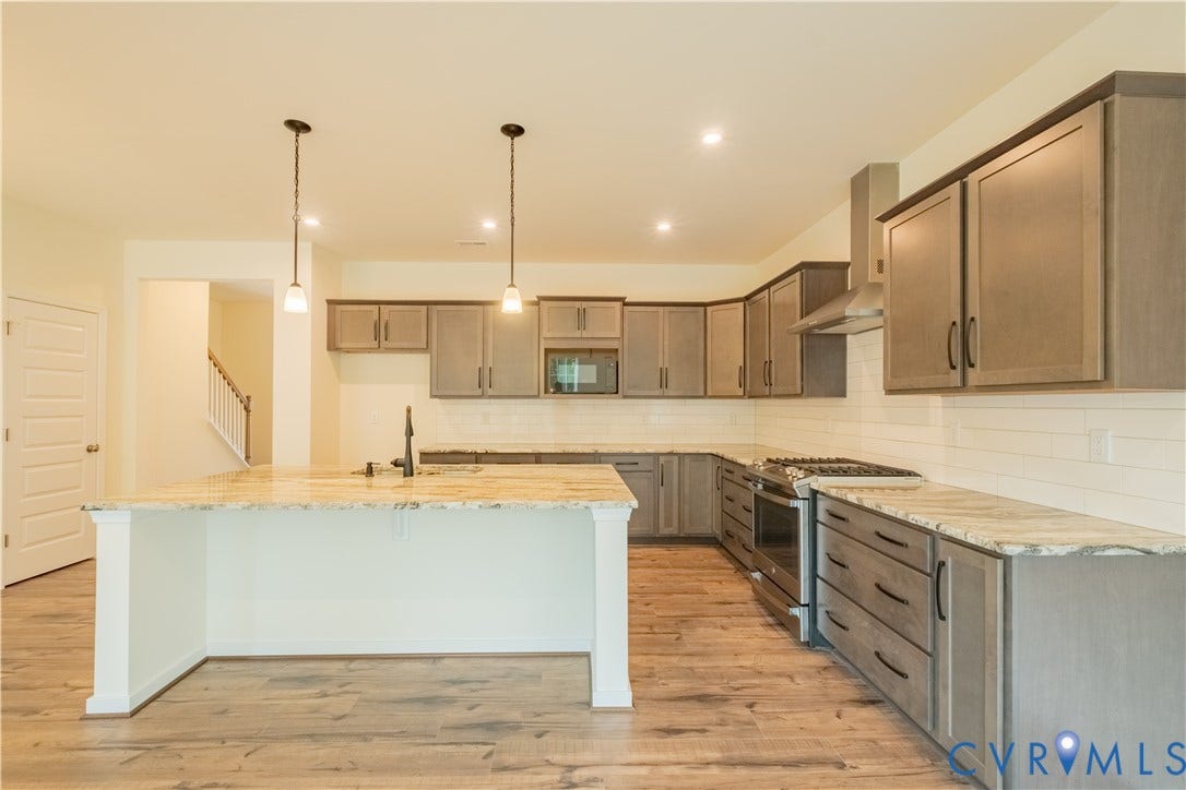 18429 Palisades Court, Chesterfield, VA 23120 Kitchen featuring a central island with dual pendant lighting, light wood-finish flooring, light gray cabinetry, stainless steel appliances, and light-toned countertops