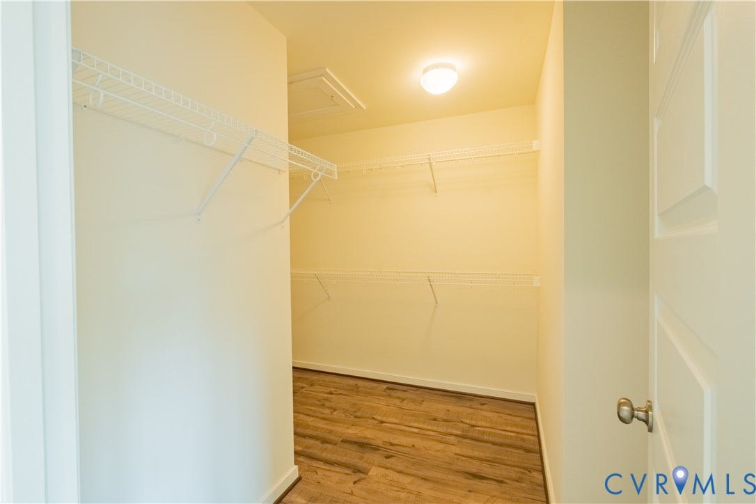 18429 Palisades Court, Chesterfield, VA 23120 Walk-in closet featuring wood-finish flooring, white wire shelving, a ceiling-mounted light fixture, and an attic access panel